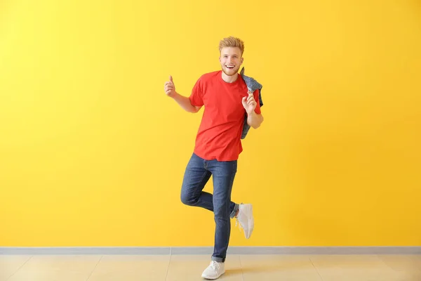 Handsome young man dancing against color wall — Stock Photo, Image