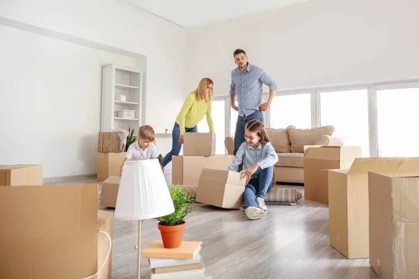 Happy family unpacking belongings in their new house — Stock Photo, Image