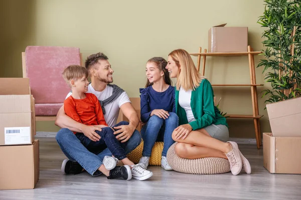Família feliz com pertences em sua nova casa — Fotografia de Stock