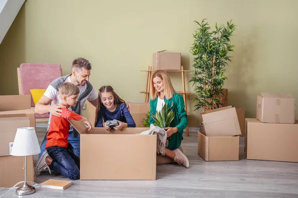 Lycklig familj uppackning tillhörigheter i deras nya hus — Stockfoto