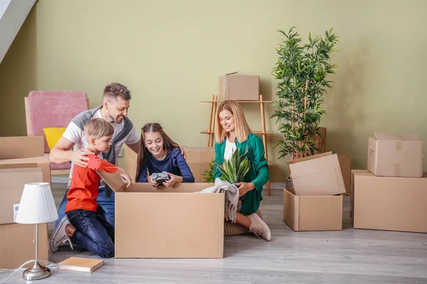 Famiglia felice disfare i bagagli nella loro nuova casa — Foto Stock