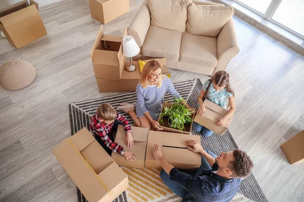 Família feliz desempacotando pertences em sua nova casa — Fotografia de Stock