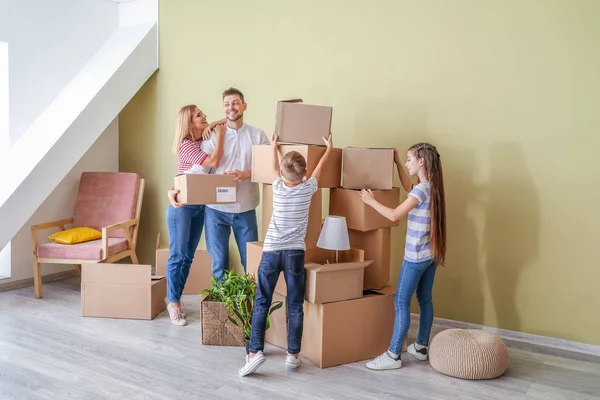 Família feliz com pertences em sua nova casa — Fotografia de Stock