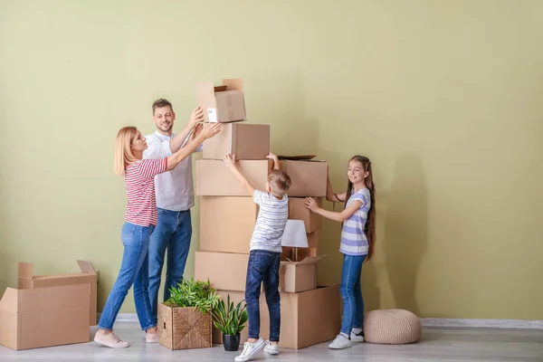 Família feliz com pertences em sua nova casa — Fotografia de Stock