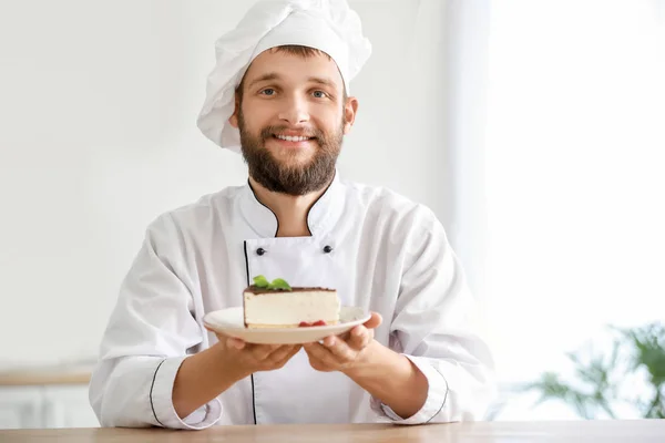 Handsome male chef with tasty cake in kitchen — Stock Photo, Image
