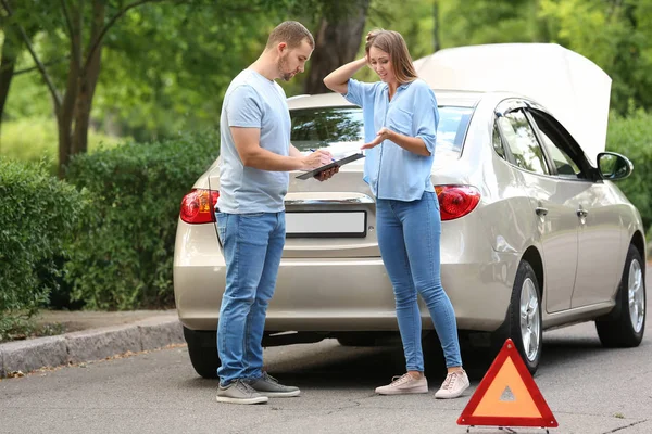 Conductor y agente de seguros cerca de coche dañado al aire libre —  Fotos de Stock