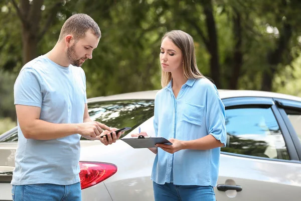 Conductor y agente de seguros cerca de coche dañado al aire libre — Foto de Stock