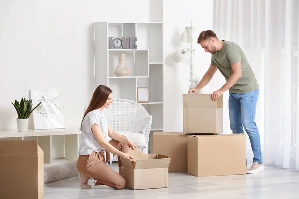 Young couple unpacking things after moving into new house — Stock Photo, Image