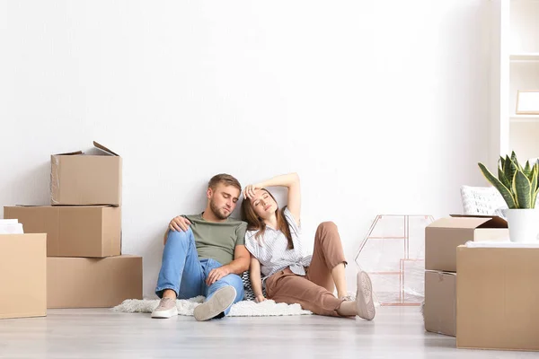 Unavení manželé sedící na podlaze po přesunu do nového domu — Stock fotografie