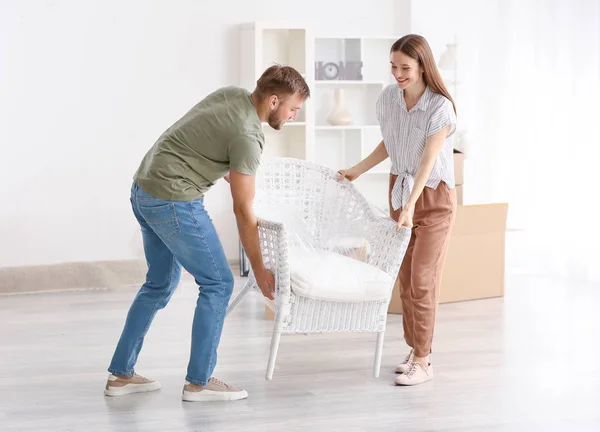 Young couple carrying furniture after moving into new house — Stock Photo, Image