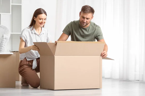 Young couple unpacking things after moving into new house — Stock Photo, Image