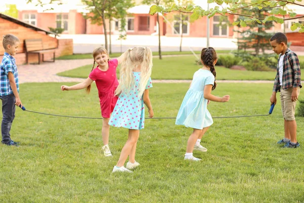 Cute little children jumping rope in park — Stock Photo, Image