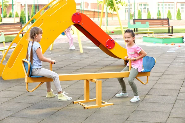 Cute little children on seesaw in park — Stock Photo, Image