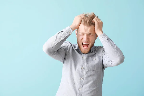 Stressed young man on color background — Stock Photo, Image