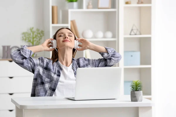 Jeune femme se détendre et écouter de la musique à la maison — Photo