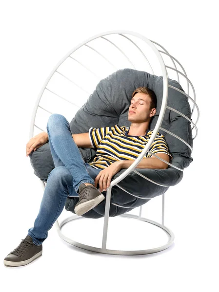 Hombre joven relajándose en sillón sobre fondo blanco — Foto de Stock