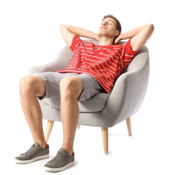 Hombre joven relajándose en sillón sobre fondo blanco — Foto de Stock