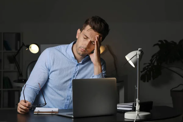 Stressad ung man på arbetsplatsen sent på kvällen — Stockfoto