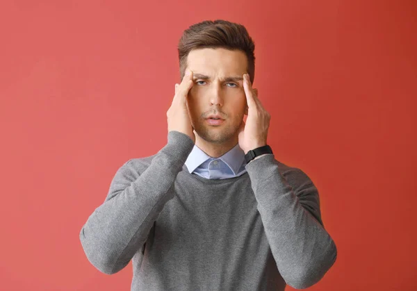 Gestresster junger Mann auf farbigem Hintergrund — Stockfoto