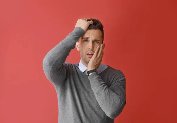 Stressed young man on color  background — Stock Photo, Image
