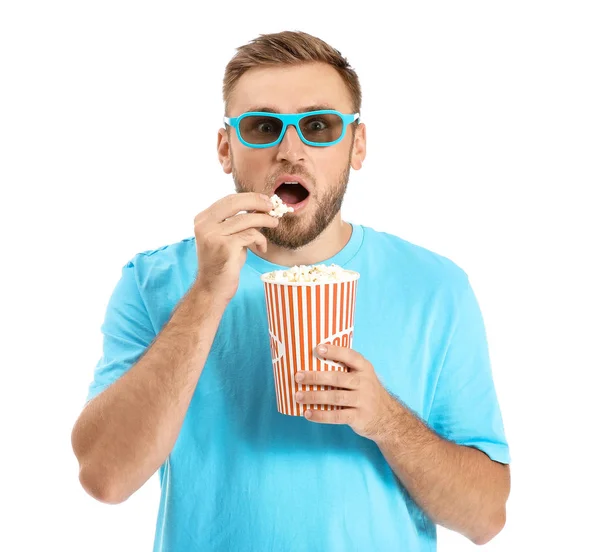 Young man with popcorn watching horror movie on white background — Stock Photo, Image