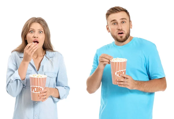 Junges Paar mit Popcorn schaut Horrorfilm auf weißem Hintergrund — Stockfoto