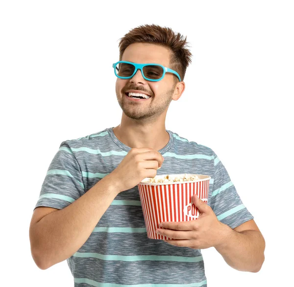 Young man with popcorn watching movie on white background — Stock Photo, Image