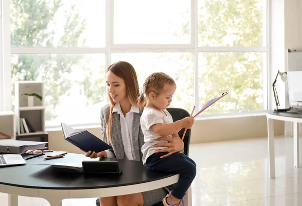 Working mother with her daughter in office