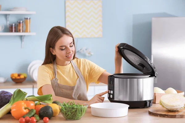 Женщина с помощью современной мульти-плита на кухне — стоковое фото