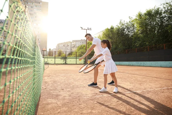 Bambina e suo padre giocano a tennis sul campo — Foto Stock