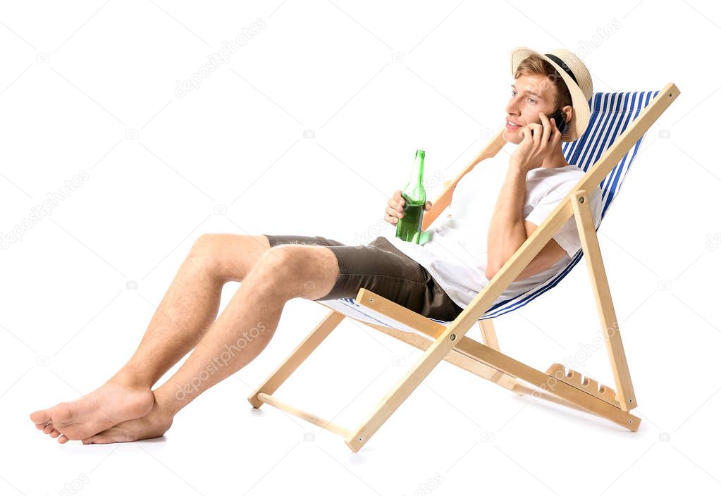 Young man relaxing on sun lounger against white background