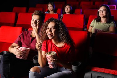 Patlamış mısırlı çift sinemada film izliyor.