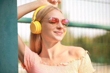 Güzel genç kadın müzik açık havada için dinleme