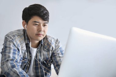 Dizüstü bilgisayar ile Asyalı öğrenci evde sınava hazırlanıyor