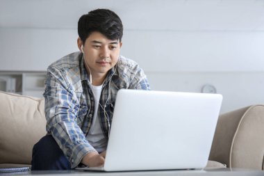 Dizüstü bilgisayar ile Asyalı öğrenci evde sınava hazırlanıyor