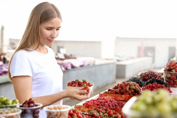 Kobieta ze świeżych truskawek na licznik na rynku — Zdjęcie stockowe