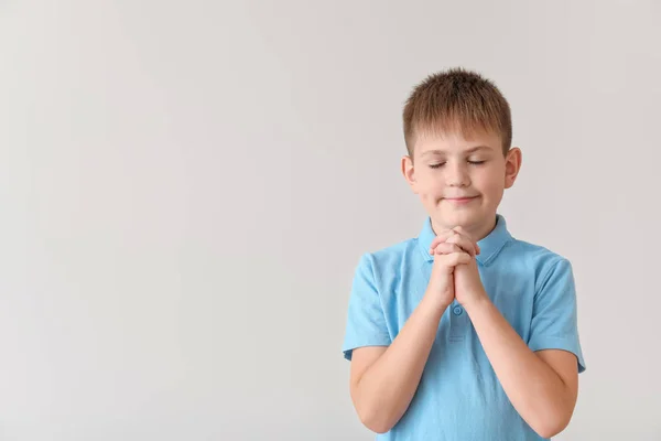 Praying little boy on light background — Stock Photo, Image