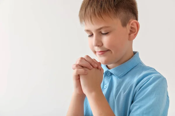 Praying little boy on light background — Stock Photo, Image