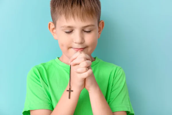 Praying little boy on color background — Stock Photo, Image