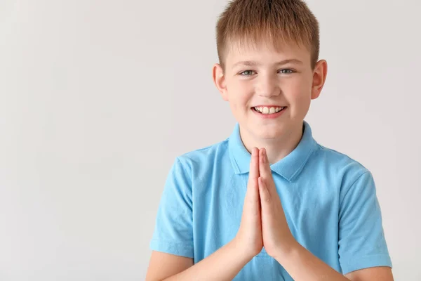 Betender kleiner Junge auf hellem Hintergrund — Stockfoto