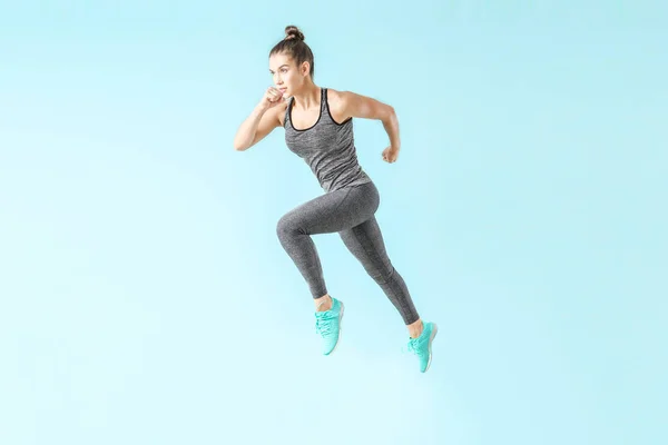 Running sporty woman on color background — Stock Photo, Image