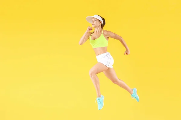 Running female tennis player on color background — Stock Photo, Image