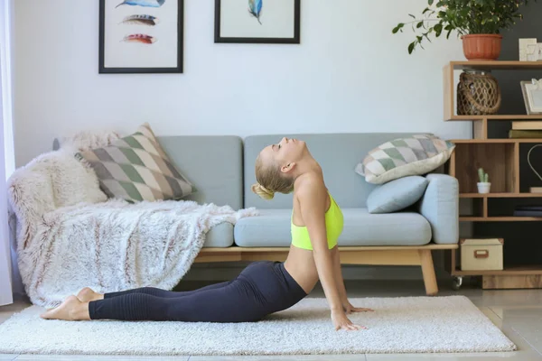 Mujer joven practicando yoga en casa — Foto de Stock