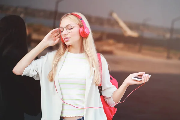 Beautiful young woman listening to music outdoors — Stock Photo, Image