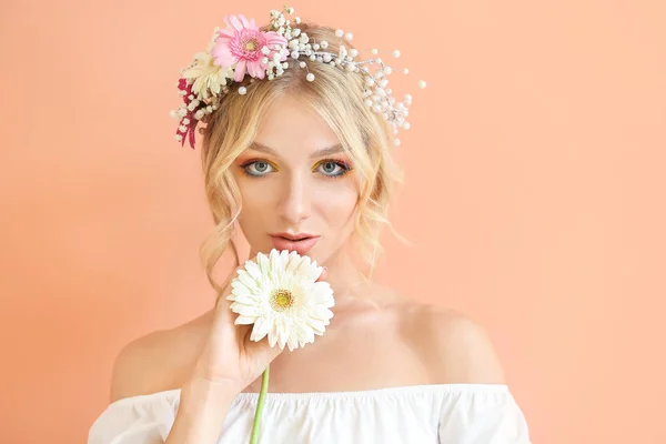 Beautiful young woman with flower wreath on color background — Stock Photo, Image