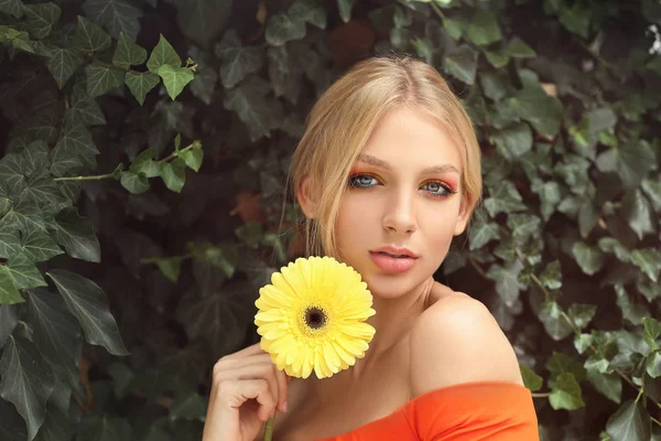 Vacker ung kvinna med Gerbera blomma utomhus — Stockfoto