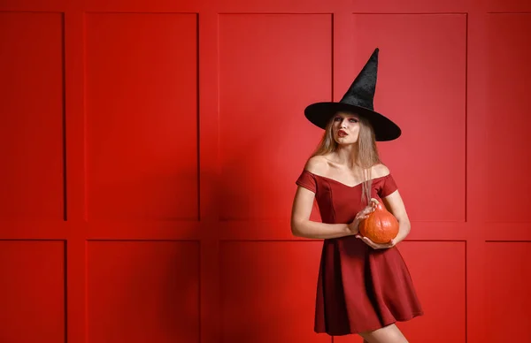 Mooie vrouw verkleed als heks voor Halloween op kleur achtergrond — Stockfoto