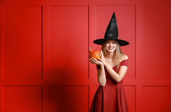 Cadı olarak Cadılar Bayramı için renk arka plan üzerinde giymiş kadın güzel — Stok fotoğraf