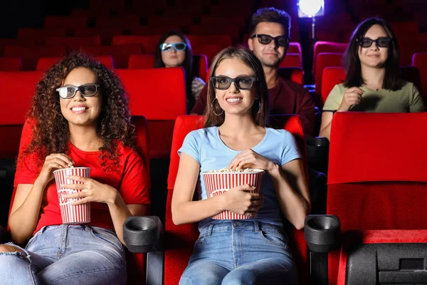 Friends with popcorn watching movie in cinema Royalty Free Stock Photos