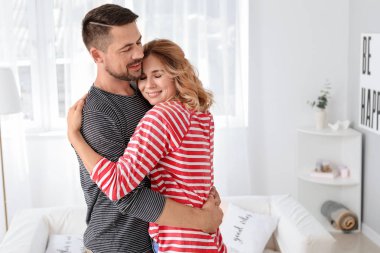 Mutlu çift evde sarılıyor.